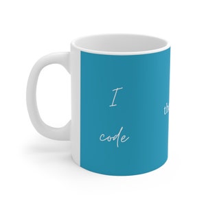 Könnte beinhalten: Weiße Keramik-Tasse mit einem blauen Feld mit dem Text "I code, therefore I am" in handschriftlichem Stil. Die Tasse hat einen gebogenen Henkel und eine glänzende Oberfläche.