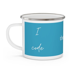 Puede incluir: Taza de esmalte blanco con borde y asa plateados. La taza presenta un panel azul brillante con las palabras "I code" en blanco, en fuente cursiva. La taza está diseñada para bebidas calientes.