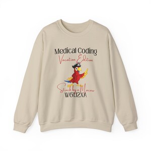 Puede incluir: Sudadera beige con un gráfico de loro colorido con un sombrero de pirata. El texto dice "Medical Coding Vacation Edition" encima del loro y "Struck by a Macaw" con un código debajo. Una prenda superior informal y cómoda.