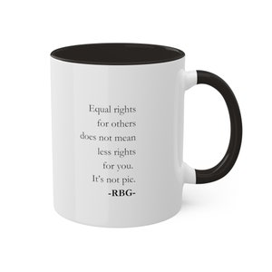 May include: White ceramic mug with a black rim and handle. The mug features a quote by Ruth Bader Ginsburg: "Equal rights for others does not mean less rights for you. It's not pie."