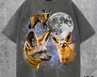 May include: Dark gray t-shirt featuring a graphic design of three fennec foxes, a full moon, and a starry background. The shirt has a vintage wash effect. The text "J&S Essential" is printed in the lower right corner.