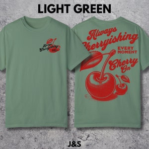 May include: Light green t-shirt with a red cherry graphic and the text "Always Cherryishing Every Moment Cherry On".
