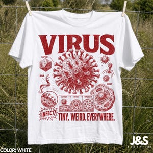 Peut inclure: Un t-shirt blanc avec une impression graphique rouge représentant un virus et des étiquettes scientifiques comme CAPSID, RNA et HOST. Le design inclut un diagramme en trois étapes ATTACH, ENTER, REPLICATE, le mot INFECT et le texte VIRUS TINY. WEIRD. EVERYWHERE.