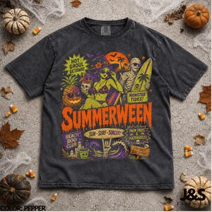 Op de afbeelding: Een antracietgrijs t-shirt met een kleurrijke grafische print met de teksten "SUMMERWEEN," "HOT GHOUL GETAWAY," "MONSTER TIDES," "BEACH BOO CLUB," "SUN-SURF-SORCERY," "PALM TREES & POLTERGEISTS" en "STAY SALTY STAY SPOOKY" met een heks en een mummie.