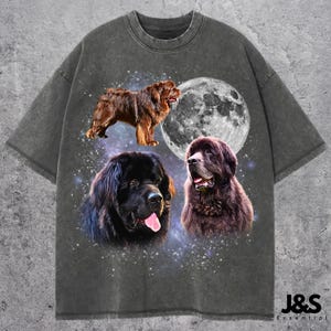 Op de afbeelding: Donkergrijs T-shirt met een ontwerp met drie portretten van Newfoundlanders en een volle maan. Het ontwerp bevat een bruine hond die staat, een zwarte hond met zijn tong uit en een bruine hond met zijn mond open. De tekst "J&S Essential" staat rechtsonder.