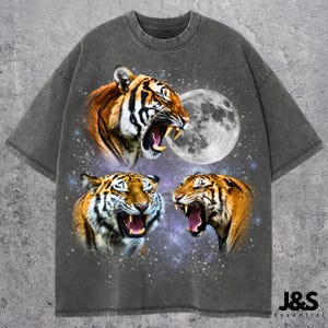 May include: A gray t-shirt with a vintage look featuring three roaring tiger faces against a galaxy background with a full moon.
