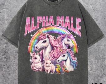May include: Dark grey t-shirt with the text "ALPHA MALE" above a rainbow and illustrations of unicorns, rabbits, and parrots. The shirt has a vintage, washed appearance.