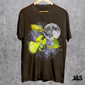 May include: Brown t-shirt featuring a vibrant graphic of leaf insects with a full moon against a starry galaxy backdrop. The design includes detailed illustrations of the insects in shades of green and yellow. The shirt has the text "J&S Essential" at the bottom.