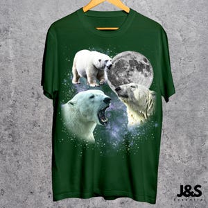 May include: A dark green t-shirt featuring a graphic design of three polar bears and a full moon against a starry background. The bears are in various poses, with one yawning. The text "J&S Essential" is at the bottom.
