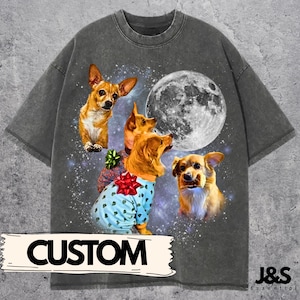 May include: Dark gray t-shirt featuring a graphic of several dogs with a full moon and starry background. One dog is wearing a blue sweater with a red bow. The word "CUSTOM" is printed on the bottom of the shirt.