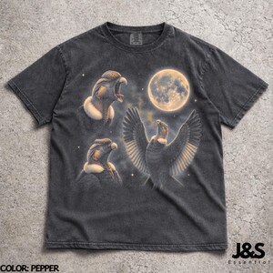 May include: Dark grey t-shirt with a condor design under a full moon. The graphic features three condor illustrations, one with outstretched wings, set against a starry night sky. The shirt has a vintage, worn appearance.