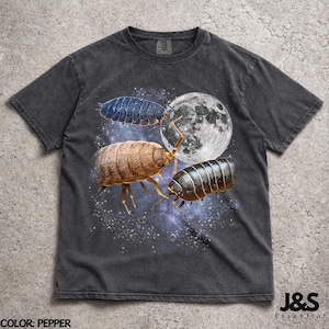 Puede incluir: Camiseta color pimienta con un diseño gráfico de tres cochinillas, una luna llena y un cielo estrellado. La camiseta tiene un lavado vintage y el texto "J&S Essential" está impreso en la parte inferior derecha.
