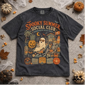 Op de afbeelding: Een antracietgrijs T-shirt met korte mouwen en een grafische print met de tekst "SPOOKY SUMMER SOCIAL CLUB" en "SUMMERWEEN BEACH PARTY". Het ontwerp bevat een geest met een zonnebril, een skelet, een pompoen-ananas en een kat.
