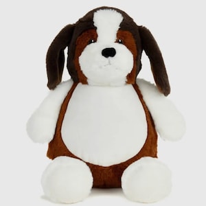 May include: A soft, plush dog toy in a seated pose. The toy features a white body, brown ears, and a brown and white head. The dog has a black nose and is made of soft, fuzzy material.