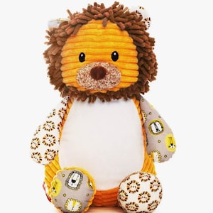 May include: A soft toy lion with a corduroy body in yellow and orange. The lion has a brown mane, a tan nose, and black eyes. The paws and arms feature a grey fabric with lion head patterns. The toy is approximately 30 cm tall.