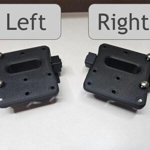 May include: Two black, rectangular mounting brackets with rounded corners, each featuring an oblong cutout and several small holes. Silver screws secure the components. The word "Left" is above one bracket, and "Right" is above the other.