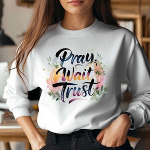 May include: White sweatshirt with a watercolor design featuring the words "Pray, Wait, Trust" in black script with green leaves and pink, orange, and blue watercolor accents.