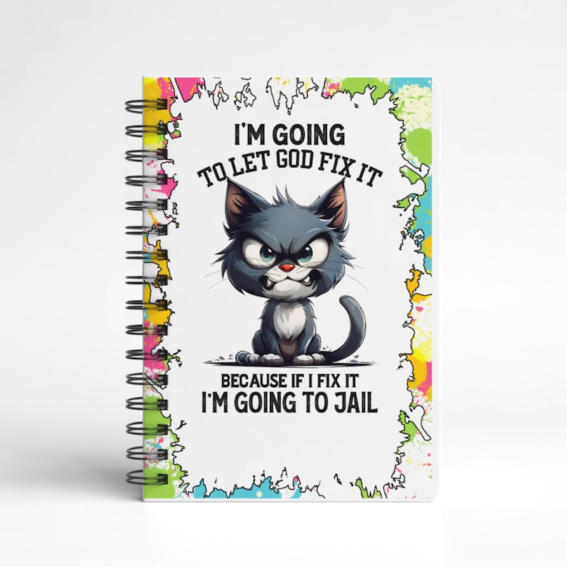K&ouml;nnte beinhalten: Spiralgebundenes Notizbuch mit einer Cartoon-Katzen-Illustration. Die Katze ist grau und hat einen w&uuml;tenden Gesichtsausdruck. Der Text auf dem Notizbuch lautet: "I'M GOING TO LET GOD FIX IT BECAUSE IF I FIX IT I'M GOING TO JAIL".