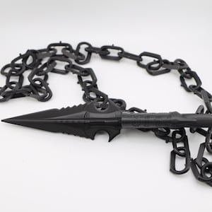 May include: A black chain with a sharp, pointed spear-like tip. The chain is made of metal and has a dark, matte finish.