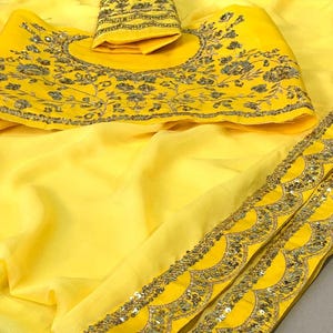 Pu&ograve; includere: Un sari giallo brillante con ricami intricati e dettagli di paillettes. Il sari presenta una blusa abbinata con ricami floreali e un bordo smerlato. Il tessuto appare leggero e fluido, ideale per occasioni speciali.