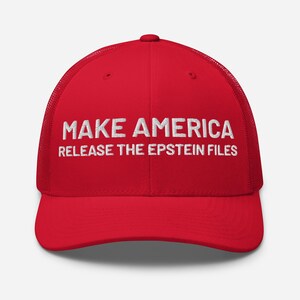 Może przedstawiać: Czerwona czapka typu trucker z białym haftowanym napisem "MAKE AMERICA RELEASE THE EPSTEIN FILES". Czapka ma siatkową tylną część i zakrzywiony daszek.