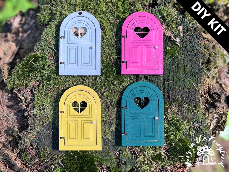May include: DIY kit for four fairy doors, each with a heart-shaped window. The doors are painted in light blue, pink, yellow, and teal.