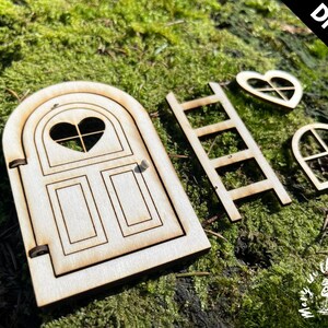 May include: DIY kit for a fairy door, featuring a wooden door with a heart-shaped window, a ladder, a heart-shaped window, and a rectangular window. The kit is made of unfinished wood and is ready to be painted or stained.
