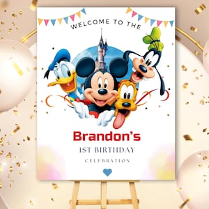 May include: A rectangular birthday sign featuring Mickey Mouse, Donald Duck, Goofy, and Pluto with a castle background. The text reads WELCOME TO THE, Brandon's, 1ST BIRTHDAY, CELEBRATION, with colorful bunting at the top and a blue heart at the bottom.