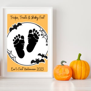 Pode incluir: Uma moldura branca com fundo laranja e texto preto que diz "Tricks, Treats & Baby Feet". H&aacute; duas pegadas de beb&ecirc; pretas dentro de um c&iacute;rculo branco com morcegos pretos e teias de aranha. O texto "Eve's First Halloween 2023" est&aacute; abaixo do c&iacute;rculo.