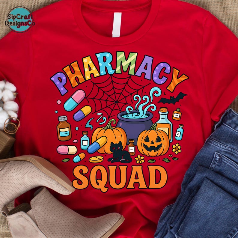 May include: Red t-shirt with a colorful "PHARMACY SQUAD" graphic. The design includes pumpkins, pills, a black cat, a spiderweb, and a cauldron. The shirt is a crew neck style.