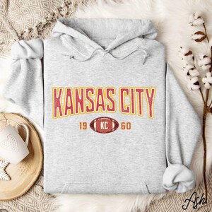 Varsity-style Chiefs hoodie for Kansas City football fans. Perfect for tailgates, Sunday football, or everyday wear. A cozy sweatshirt designed for football fanatics, showcasing Chiefs fandom and making a great fan gift.