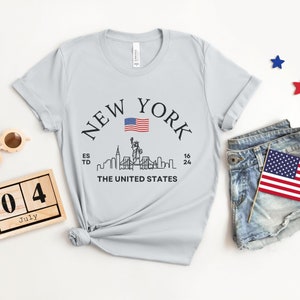 New York Skyline T-Shirt, US Flag Shirt, NYC Skyline Tee, Patriotic NYC Shirt, American Flag Apparel, NYC Skyline Graphic Tee, Statue of Liberty Shirt, NYC Landscape Shirt, Empire State Shirt, NYC Flag Tee, New York City Graphic Tee,