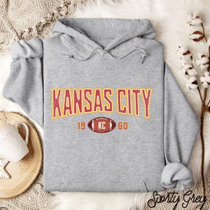 Varsity-style Chiefs hoodie for Kansas City football fans. Perfect for tailgates, Sunday football, or everyday wear. A cozy sweatshirt designed for football fanatics, showcasing Chiefs fandom and making a great fan gift.