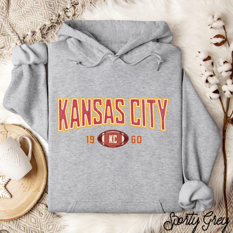 Varsity-style Chiefs hoodie for Kansas City football fans. Perfect for tailgates, Sunday football, or everyday wear. A cozy sweatshirt designed for football fanatics, showcasing Chiefs fandom and making a great fan gift.