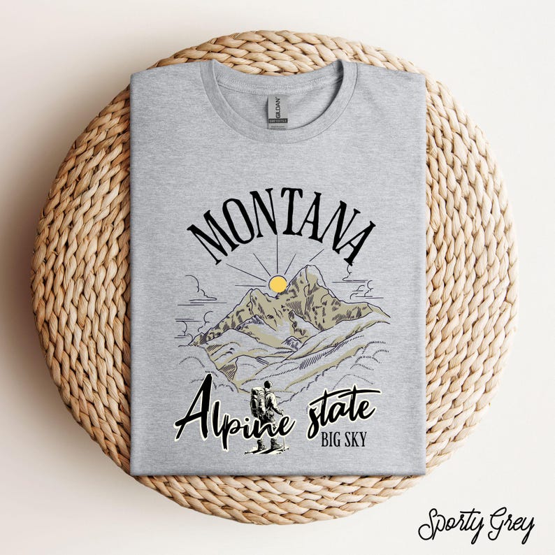 Folded Gildan 64000 Montana hiking tee with nature-inspired graphic, soft cotton fabric
