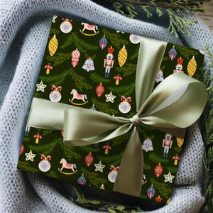 May include: A wrapped gift with Christmas-themed wrapping paper. The dark green paper features ornaments, stars, rocking horses, and nutcrackers. A light green satin ribbon is tied in a bow around the package.