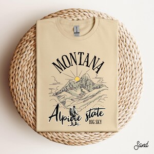 Folded Gildan 64000 Montana hiking tee with nature-inspired graphic, soft cotton fabric