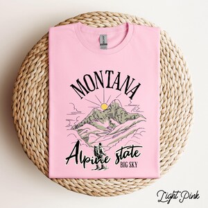 Folded Gildan 64000 Montana hiking tee with nature-inspired graphic, soft cotton fabric