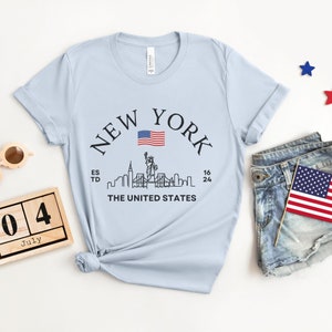 New York Skyline T-Shirt, US Flag Shirt, NYC Skyline Tee, Patriotic NYC Shirt, American Flag Apparel, NYC Skyline Graphic Tee, Statue of Liberty Shirt, NYC Landscape Shirt, Empire State Shirt, NYC Flag Tee, New York City Graphic Tee,