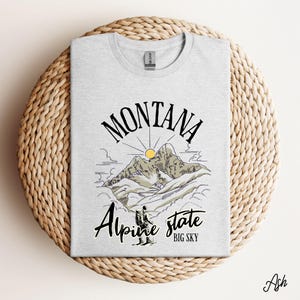 Folded Gildan 64000 Montana hiking tee with nature-inspired graphic, soft cotton fabric