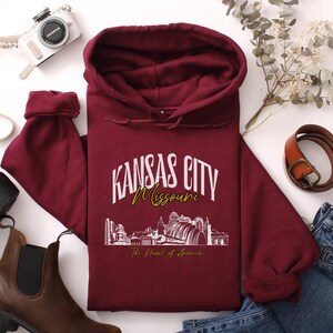 Retro oversized Kansas City skyline Hoodie with vintage cityscape design. Unisex hooded sweatshirt perfect for Kansas City fans and Missouri State lovers. Unique varsity-style Kansas City fan shirt with bold city skyline graphic.