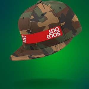 Op de afbeelding: Een baseballpet met camouflageprint, een rode band en witte tekst die "SOLD OUT" zegt.