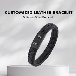 May include: Black leather bracelet with a stainless steel clasp. The clasp is engraved with the names "Jaun" and "Liza".