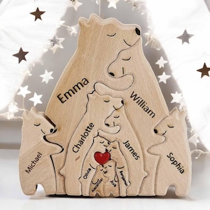 May include: Wooden bear family puzzle with names engraved: Emma, William, Michael, Charlotte, James, Sophia, Olivia, Alexander, Ava, and Benjamin. A red heart is in the center. The puzzle is made of light-colored wood.