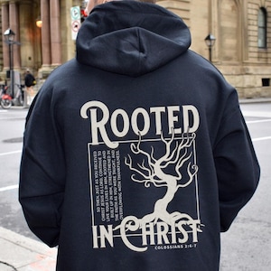 May include: Black hoodie with a white graphic print of a tree with roots and the text "ROOTED IN CHRIST" and "COLOSSIANS 2:6-7".