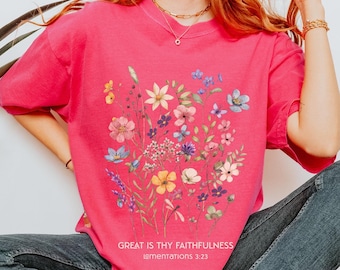 May include: A pink t-shirt with a floral print and the text "Great is thy faithfulness Lamentations 3:23".