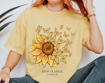 May include: A yellow t-shirt with a sunflower and butterflies graphic. The text "GROW IN GRACE 2 PETER 3:18" is printed below the graphic.