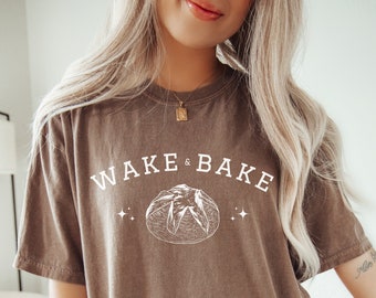 Könnte beinhalten: Ein braunes Oversize-T-Shirt mit dem Text "WAKE & BAKE" und einer Zeichnung eines Laibes Brot.