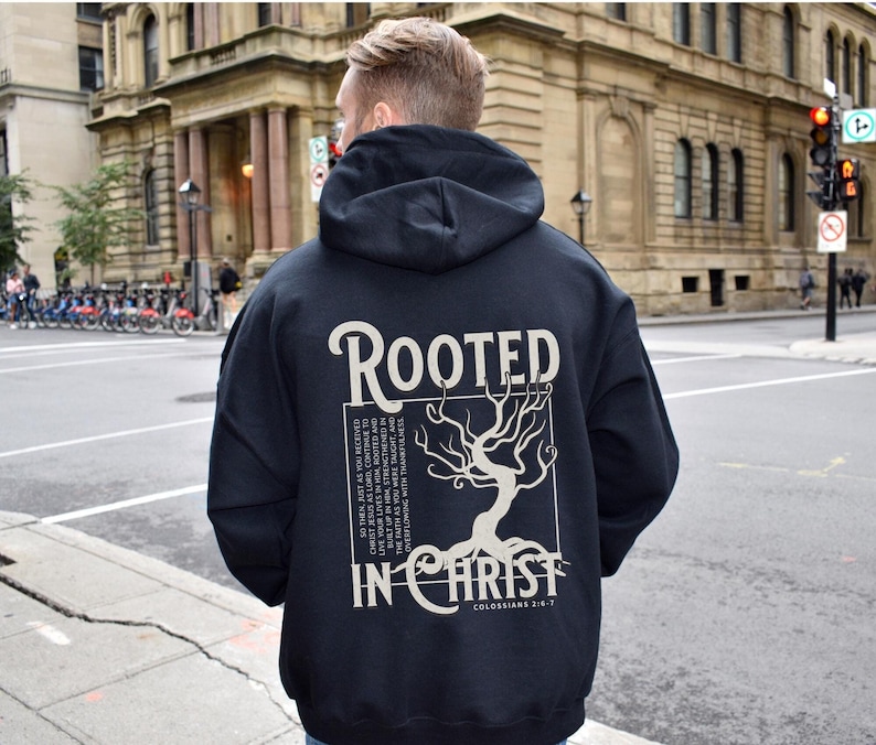 May include: Black hoodie with a white graphic print of a tree with roots and the text "ROOTED IN CHRIST" and "COLOSSIANS 2:6-7".