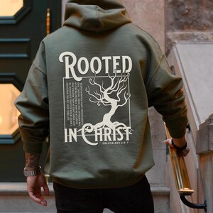 May include: A green hooded sweatshirt with a white graphic print of a tree with roots and the text "Rooted in Christ" and "Colossians 2:6-7".